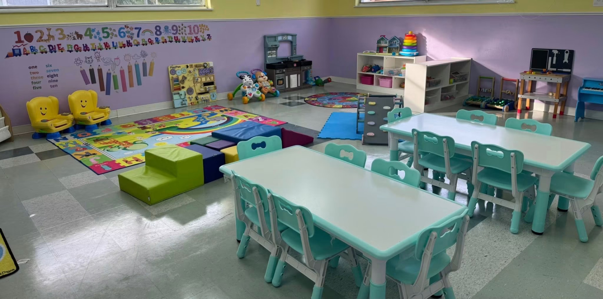 Bright preschool classroom with learning tables and activity centers