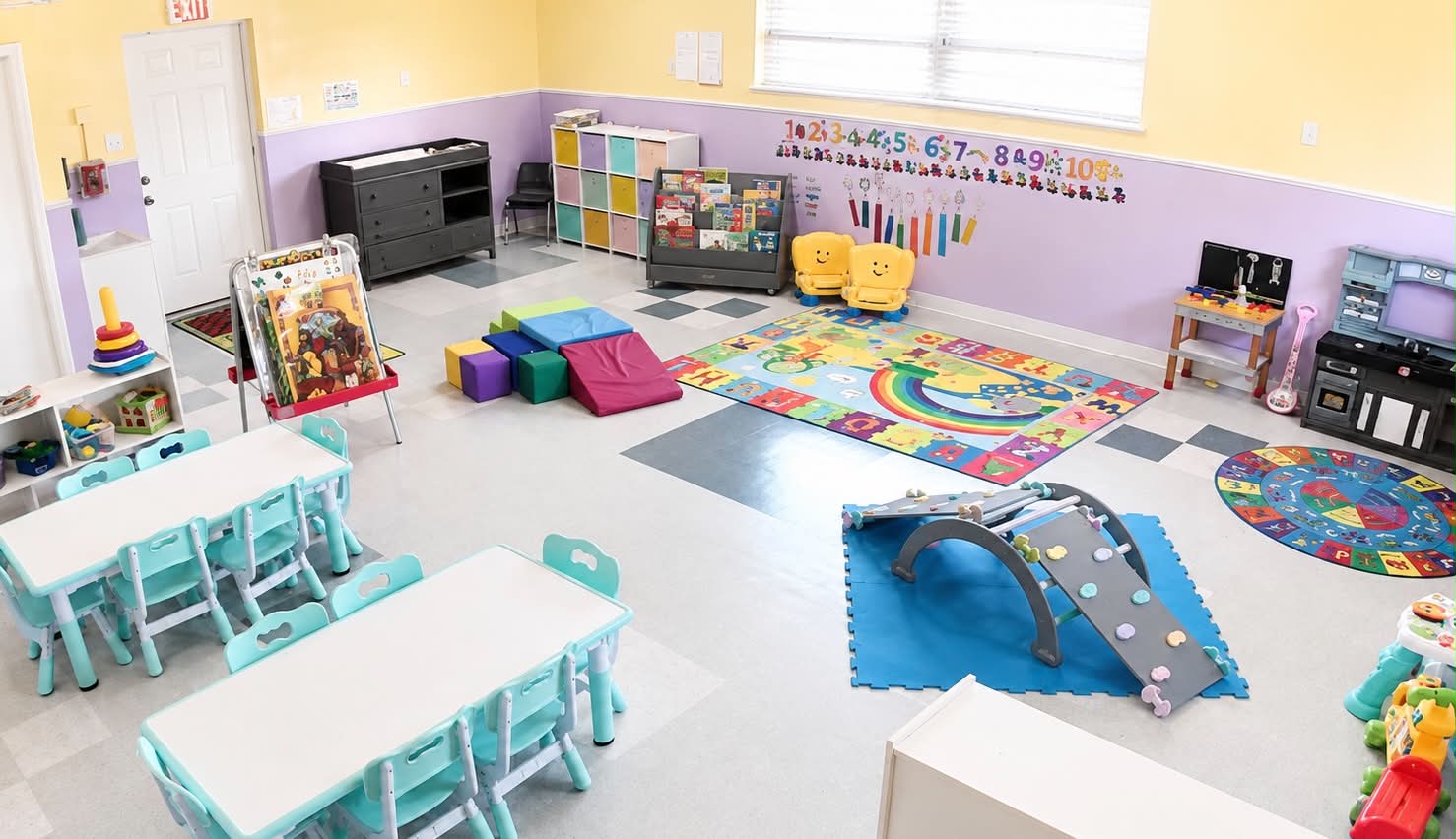 Toddler classroom with reading nook, climbing ramp and number wall display